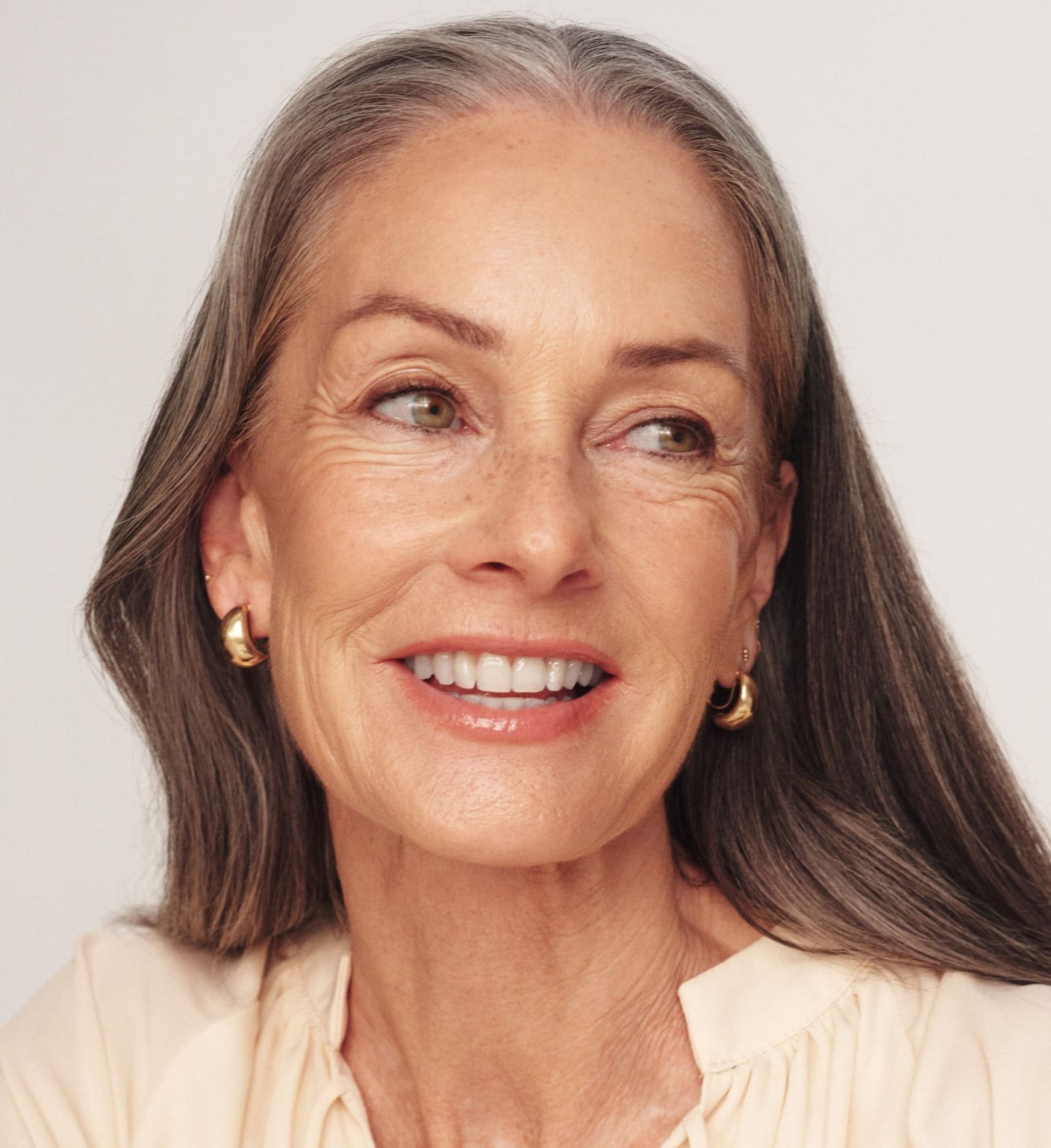 The Valentines Bundle featuring The Soft Tan Bronzer on a smiling model with grey hair for a radiant glow.