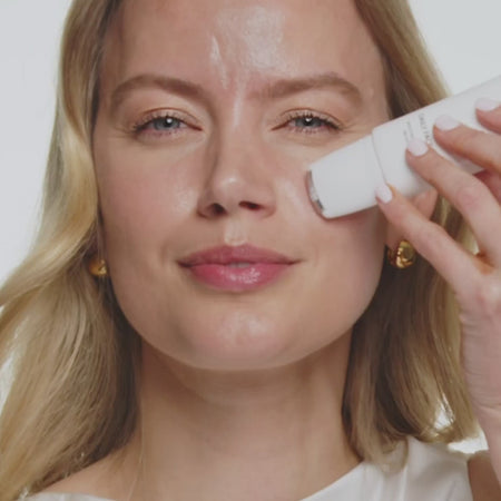 Applying Daily Face SPF 40 with a cooling rollerball for a radiant, summer-proof complexion.