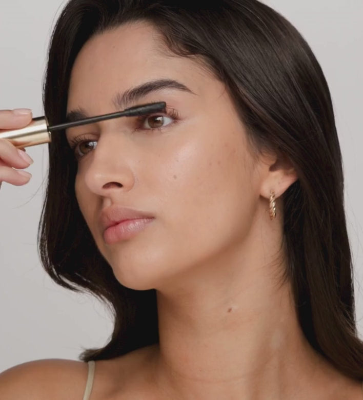 A model applies Gilded Lashes Mascara for defined, voluminous lashes.