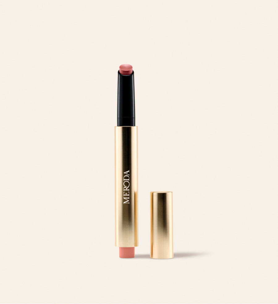 Hydrating Lip Tint in Dusty Rose: a sleek gold click pen with its cap removed on a cream background.