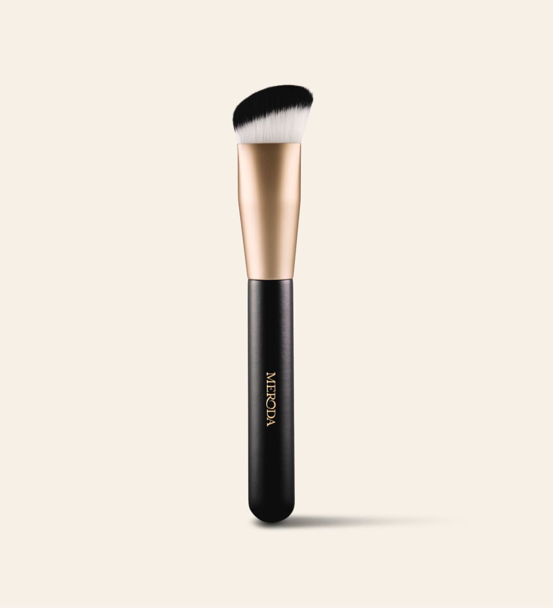 The Essential Brush featuring a black wooden handle and dense triangular bristles for seamless foundation blending.