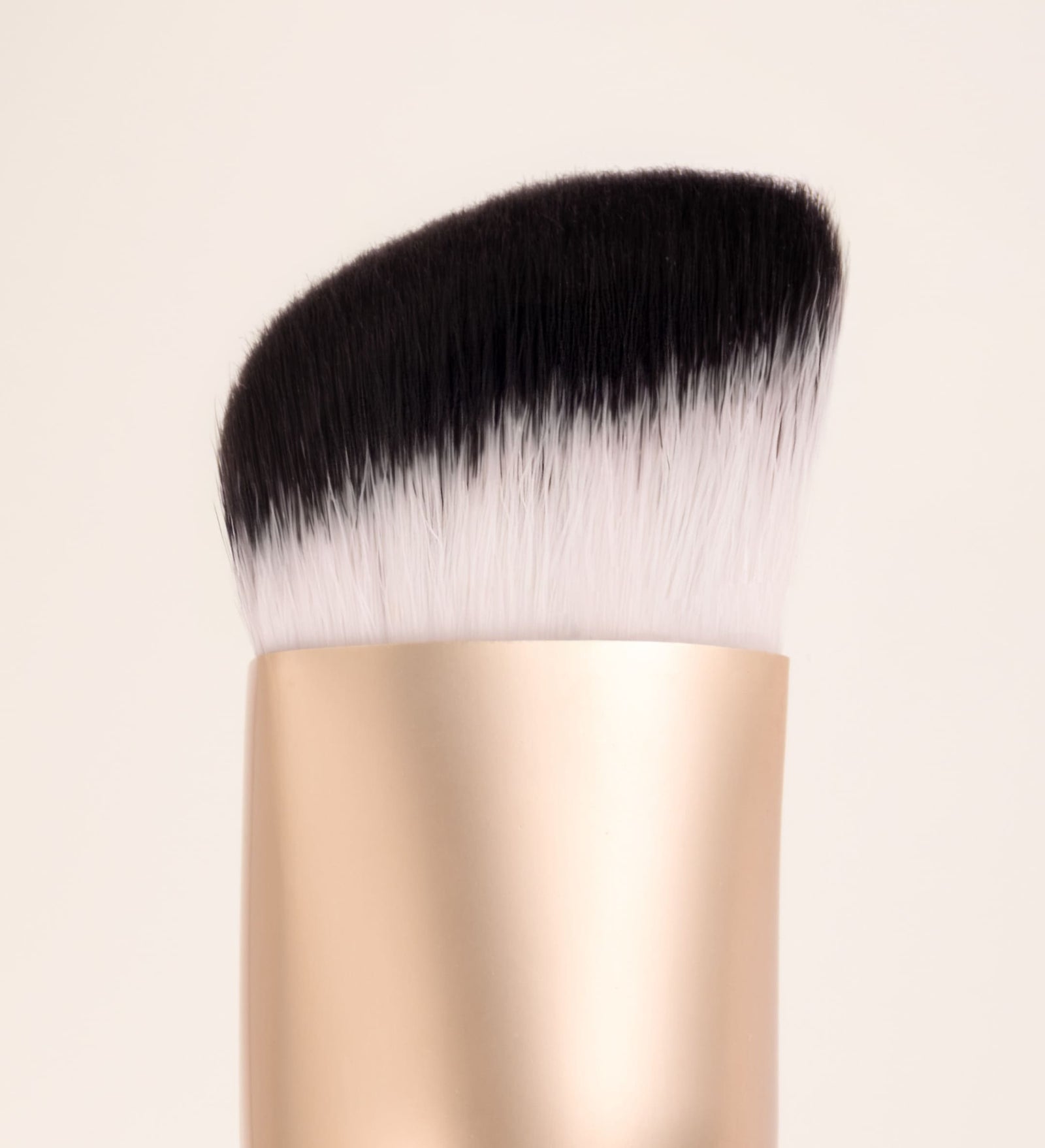 The Essential Brush featuring dense bicolour synthetic bristles and a gold ferrule for precision blending.